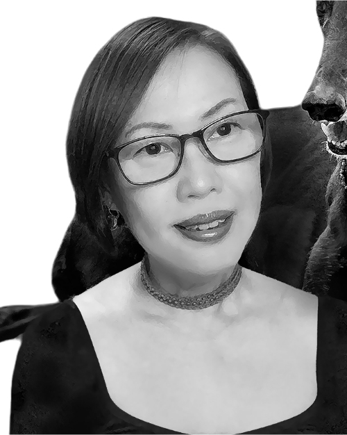 Black and white photo of Dawn-Joy Leong, she is smiling, wears glasses and is wearing a dark top
