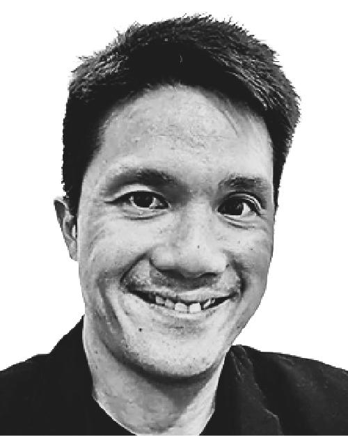 Black and white photo of Darren Ho, he is smiling, has short hair and is wearing a black collared top